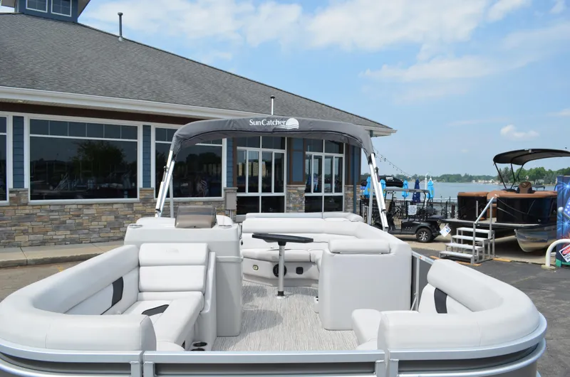 Slide: The Image of 2021 SunCatcher Select Series 20c pontoon boat docked near a lakeside building. - 8