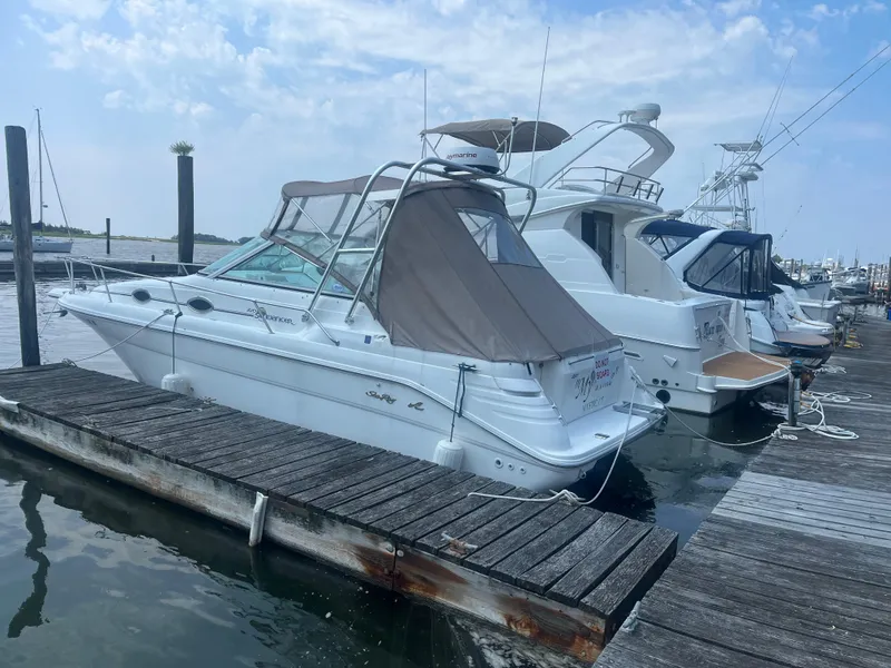 The Image of 1998 Sea Ray 27 Sundancer docked at marina under clear sky. - 0