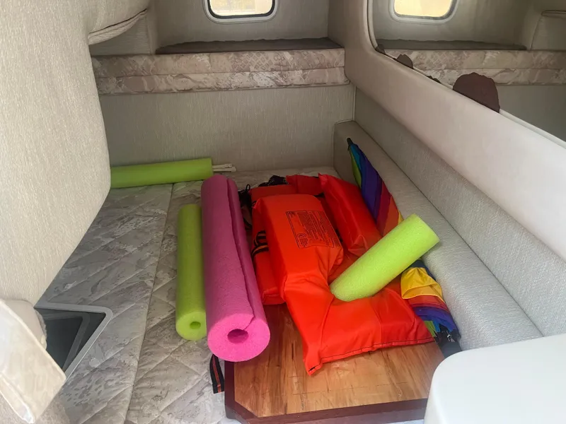 Slide: The Image of Interior of 1998 Sea Ray 27 Sundancer with life jackets and pool noodles. - 10