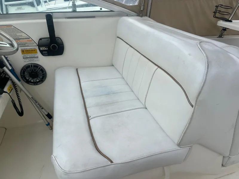 Slide: The Image of 1998 Sea Ray 27 Sundancer boat interior with white seating and control panel. - 12