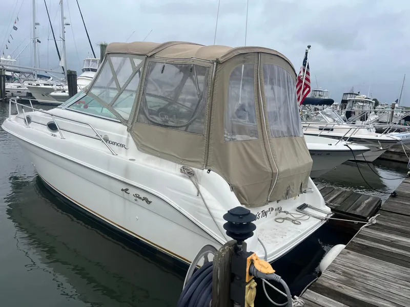 Slide: The Image of 1998 Sea Ray 27 Sundancer docked at marina, beige canopy, overcast sky. - 16