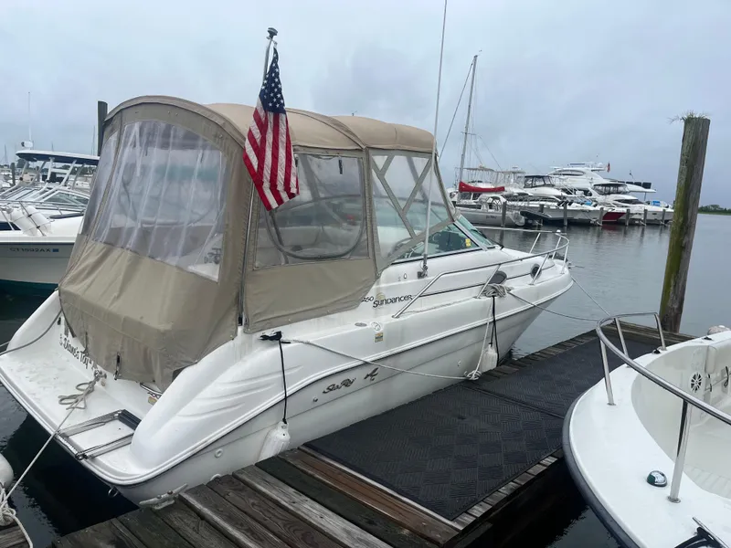 Slide: The Image of 1998 Sea Ray 27 Sundancer docked with American flag, marina background. - 17