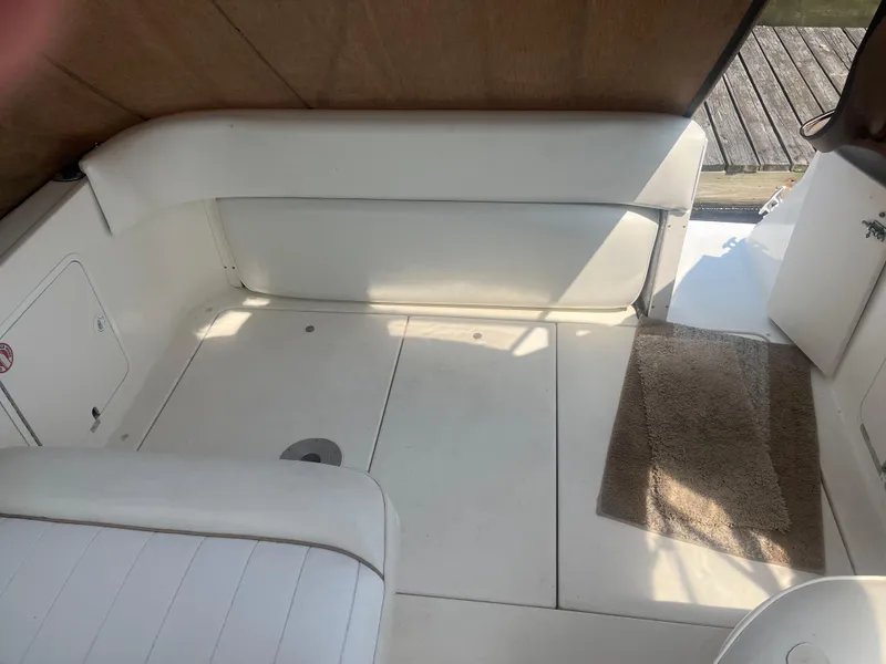 Slide: The Image of 1998 Sea Ray 27 Sundancer interior with white seating and carpeted floor. - 4