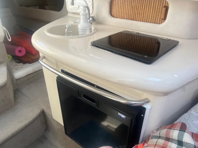 Slide: The Image of 1998 Sea Ray 27 Sundancer interior with kitchenette, sink, and mini fridge. - 8