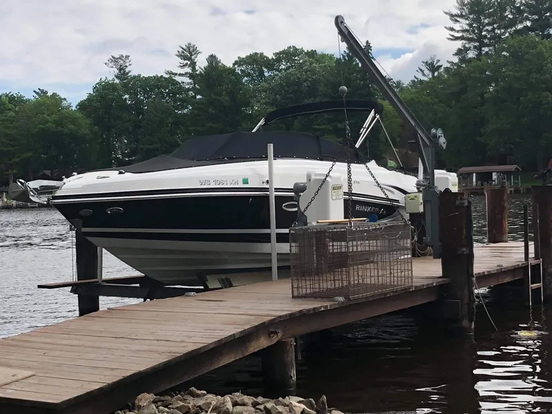 Slide: The Image of 2013 Rinker 276 Captiva Bowrider docked on a serene lake. - 1