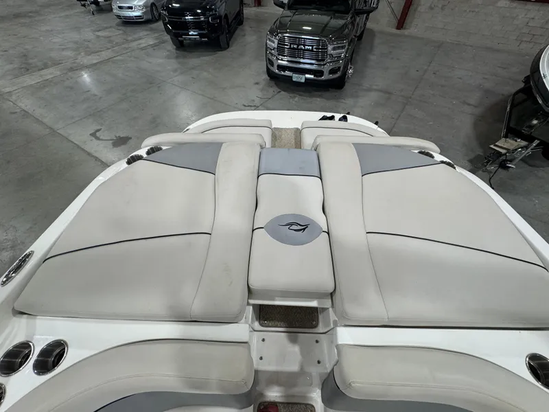 Slide: The Image of 2013 Rinker 276 Captiva Bowrider boat interior with cushioned seating in a garage. - 28