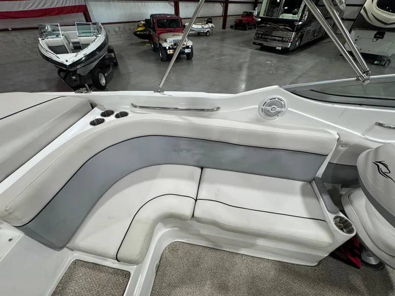 Slide: The Image of 2013 Rinker 276 Captiva Bowrider interior with white and gray seating in a showroom. - 29