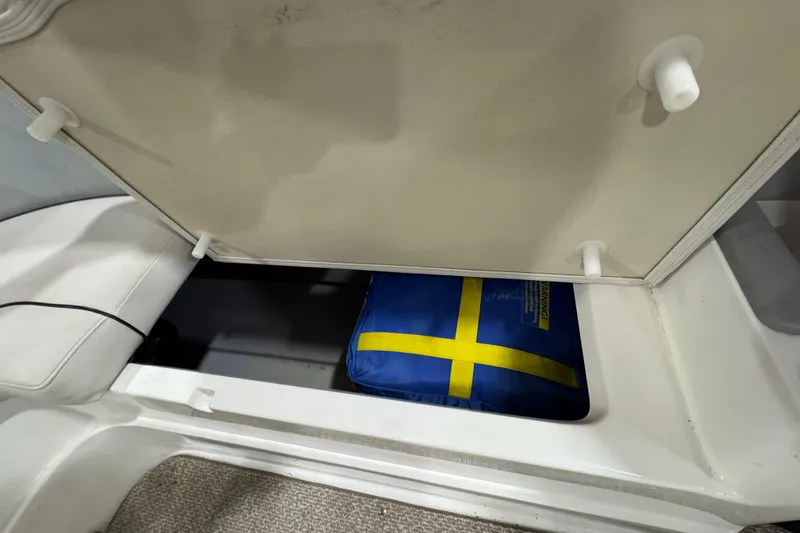 Slide: The Image of Storage compartment in 2013 Rinker 276 Captiva Bowrider with blue and yellow bag. - 30
