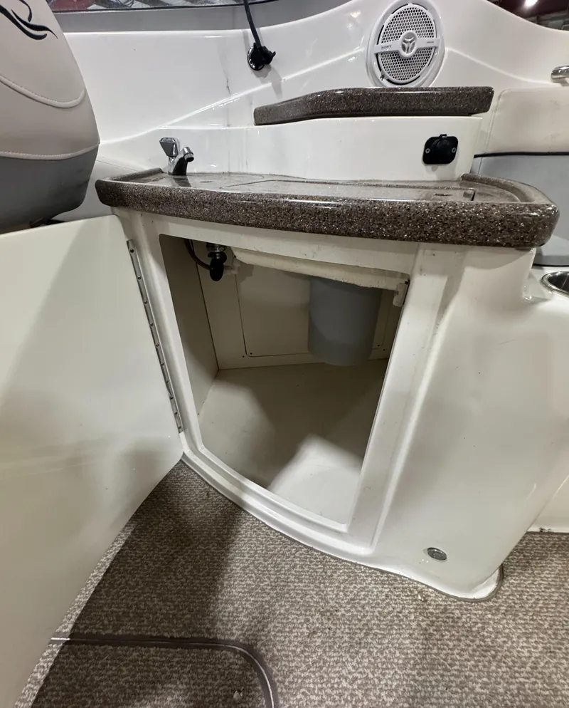 Slide: The Image of 2013 Rinker 276 Captiva Bowrider interior storage compartment with open door. - 32