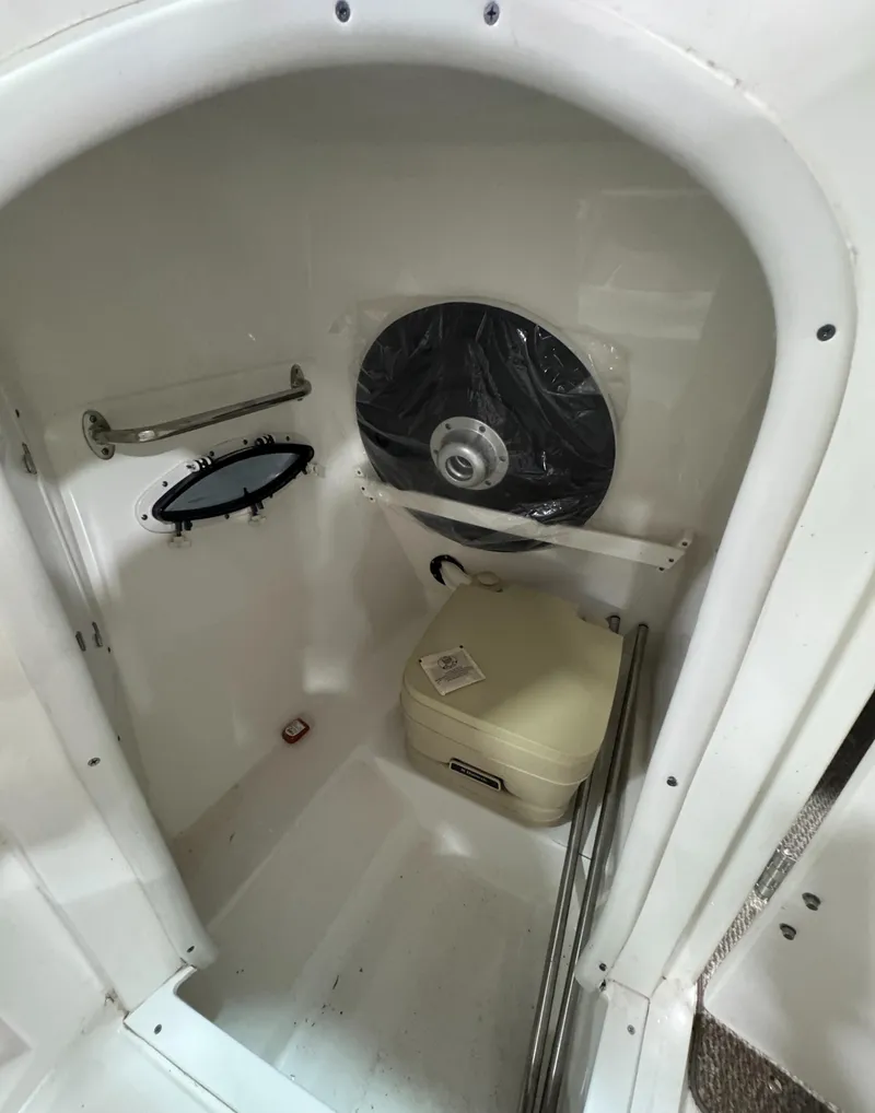 Slide: The Image of 2013 Rinker 276 Captiva Bowrider interior cabin with portable toilet and porthole. - 41