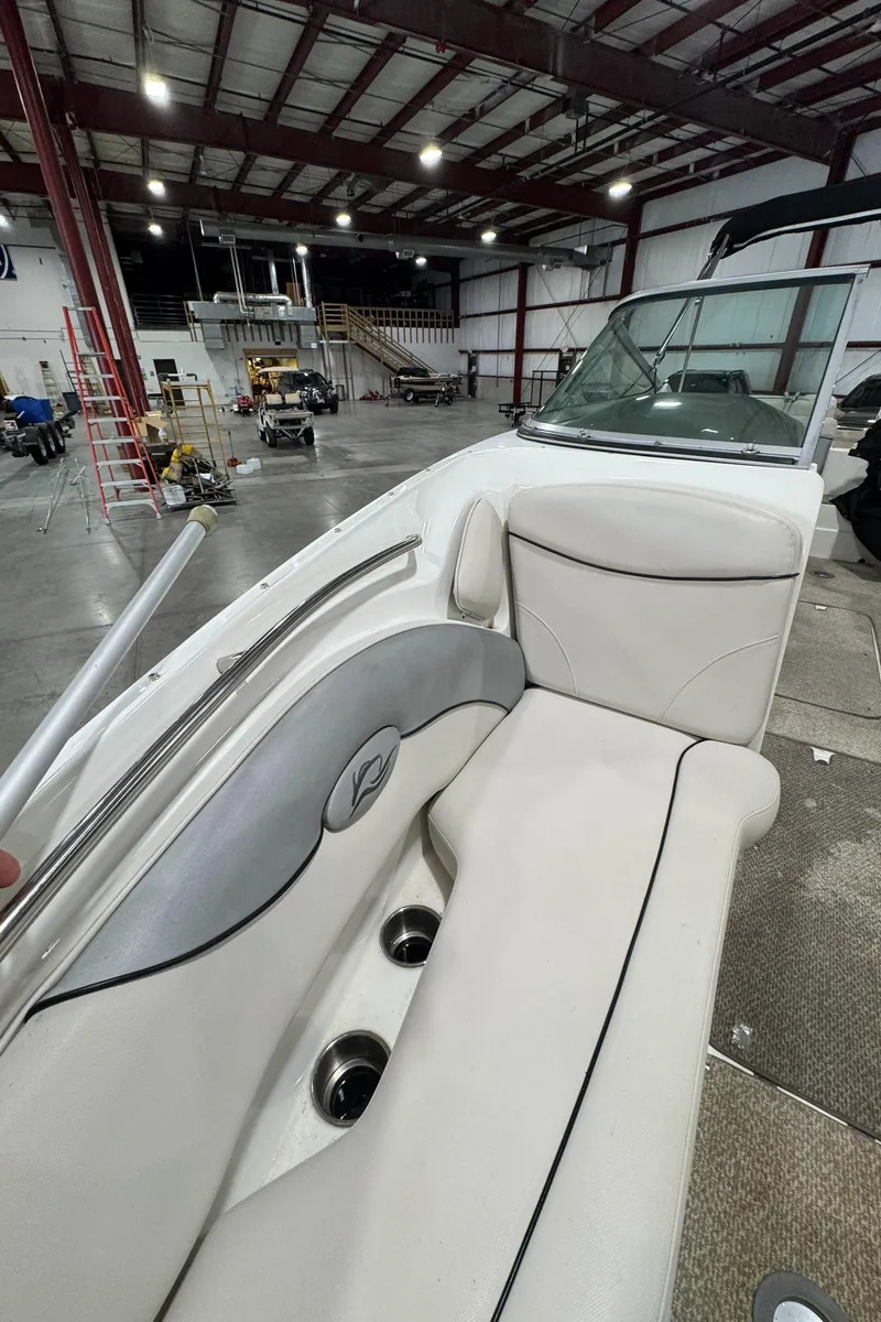 Slide: The Image of 2013 Rinker 276 Captiva Bowrider interior in a spacious warehouse setting. - 47