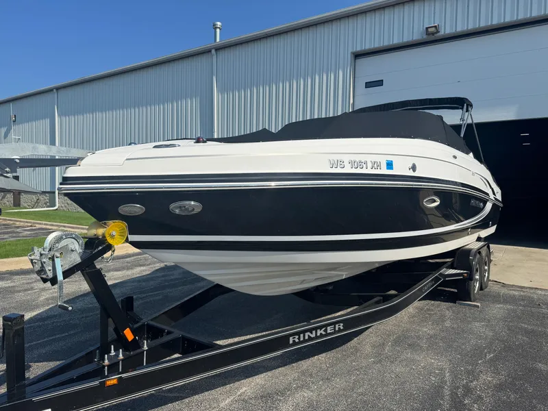 Slide: The Image of 2013 Rinker 276 Captiva Bowrider on trailer outside a warehouse. - 5
