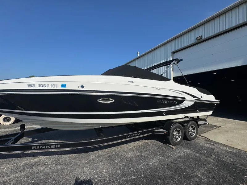 Slide: The Image of 2013 Rinker 276 Captiva Bowrider on trailer outside a warehouse. - 6