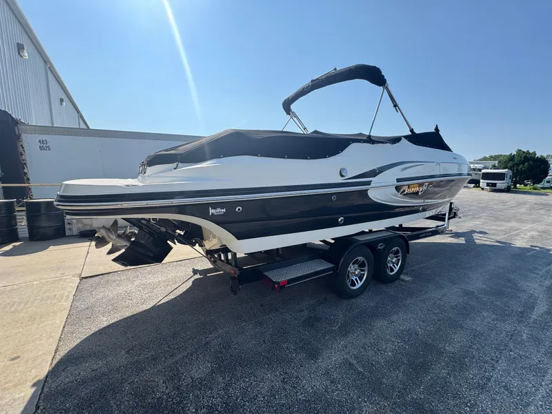 Slide: The Image of 2013 Rinker 276 Captiva Bowrider on trailer, parked outdoors under clear sky. - 8