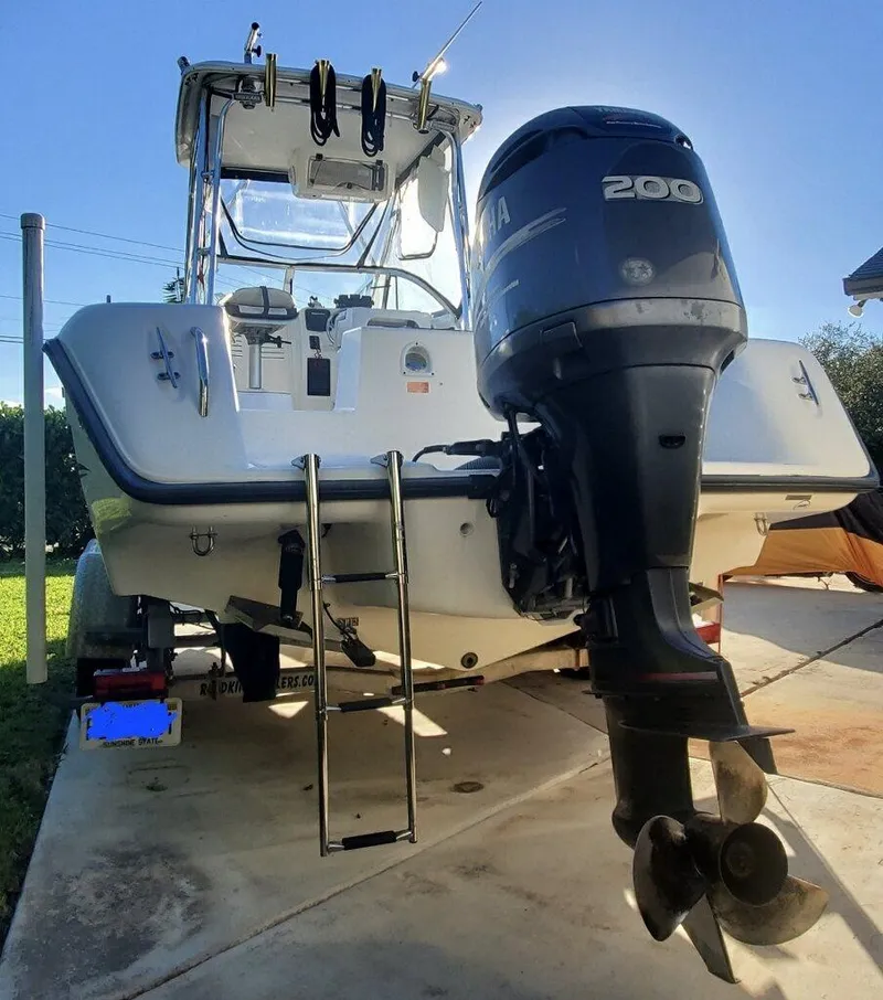 Slide: The Image of 2003 Century 24 Walkaround boat with Yamaha 200 engine, parked on driveway. - 4