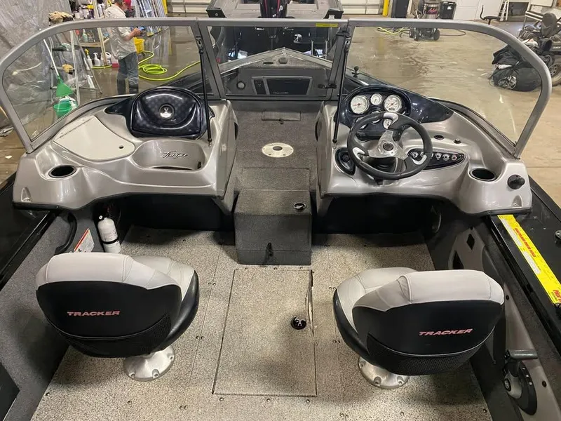 Slide: The Image of 2014 Tracker Targa V-18 WT boat interior with dual seats and dashboard controls. - 13