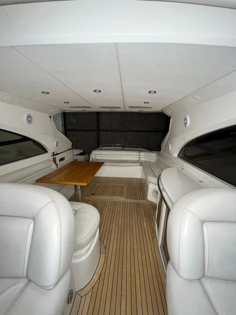Slide: The Image of Luxurious interior of 2002 Sunseeker Predator 61 yacht with white seating and wooden table. - 23