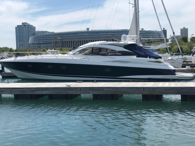 Slide: The Image of 2002 Sunseeker Predator 61 yacht docked in a marina with cityscape background. - 3