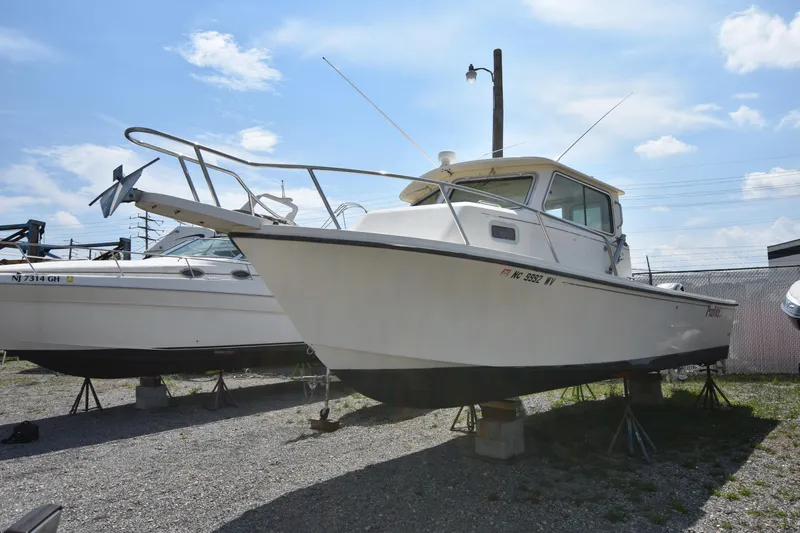 Slide: The Image of 2004 Parker 2520 Deep Vee Sport Cabin boat on stands, outdoor storage. - 1