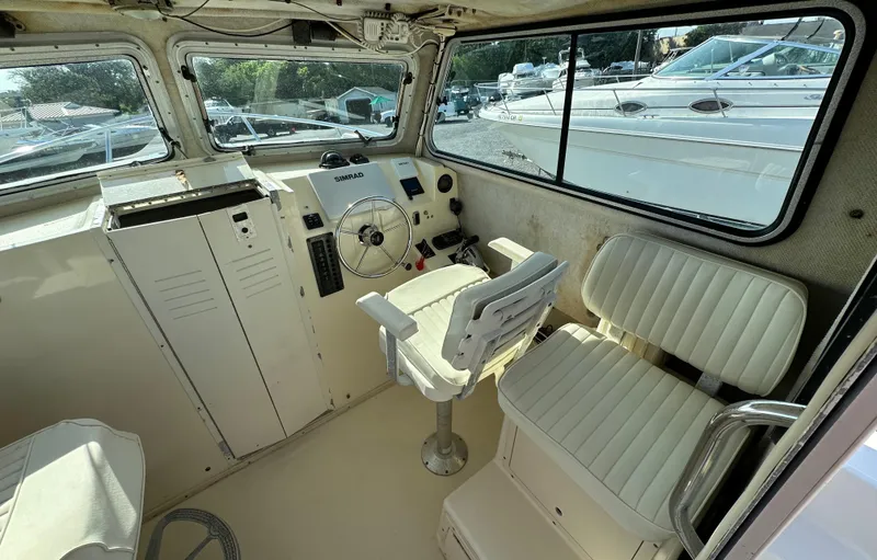 Slide: The Image of 2004 Parker 2520 Deep Vee Sport Cabin interior with helm and seating. - 10