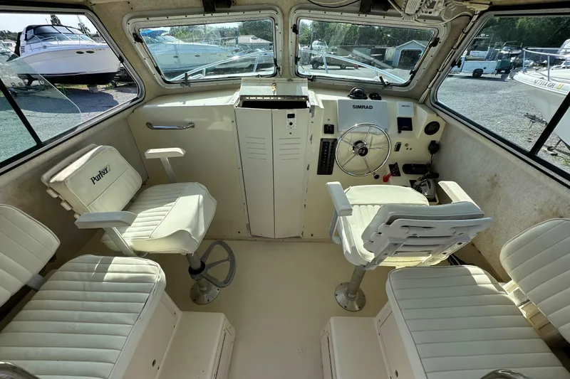 Slide: The Image of 2004 Parker 2520 Deep Vee Sport Cabin interior with helm and seating. - 12