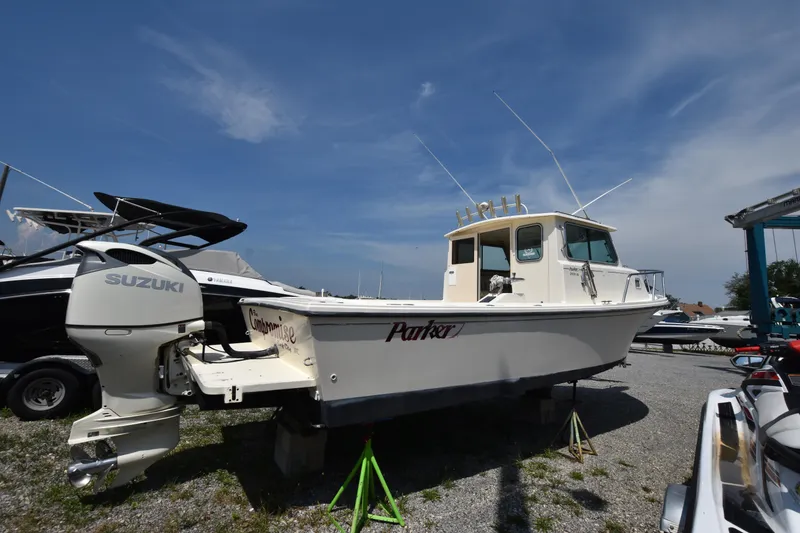 Slide: The Image of 2004 Parker 2520 Deep Vee Sport Cabin boat on display, featuring Suzuki outboard motor. - 2