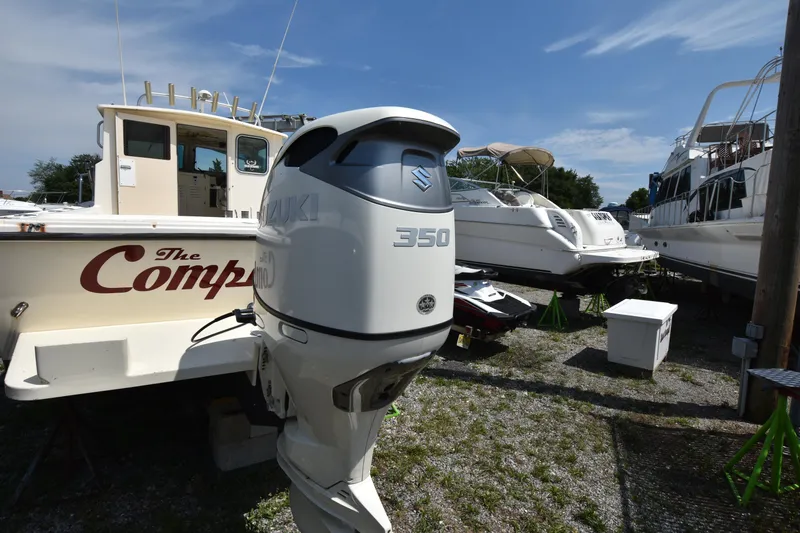 Slide: The Image of 2004 Parker 2520 Deep Vee Sport Cabin with Suzuki 350 outboard motor in a boatyard. - 4