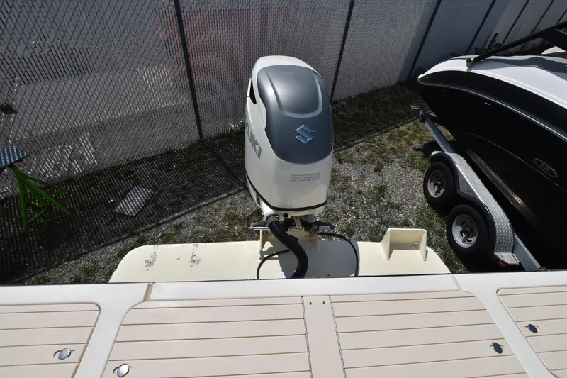 Slide: The Image of 2004 Parker 2520 Deep Vee Sport Cabin with Suzuki outboard motor, docked near a trailer. - 7