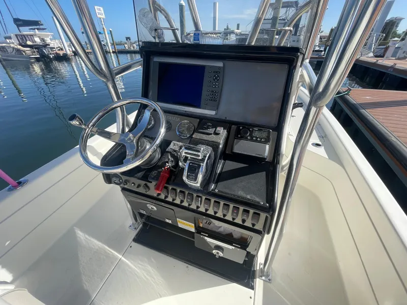 Slide: The Image of 2011 ShearWater 25LTZ boat console with steering wheel and navigation system at marina. - 12