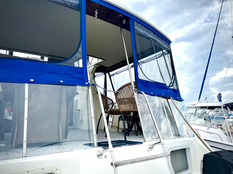 Slide: The Image of 1986 Chris-Craft 480 Corinthian yacht with blue canopy and wicker chairs on deck. - 10