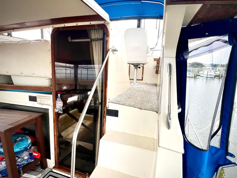 Slide: The Image of Interior view of 1986 Chris-Craft 480 Corinthian yacht with stairs and marina backdrop. - 14