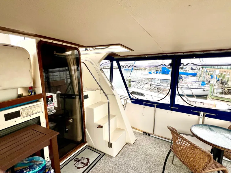Slide: The Image of 1986 Chris-Craft 480 Corinthian yacht interior with stairs, seating, and marina view. - 15