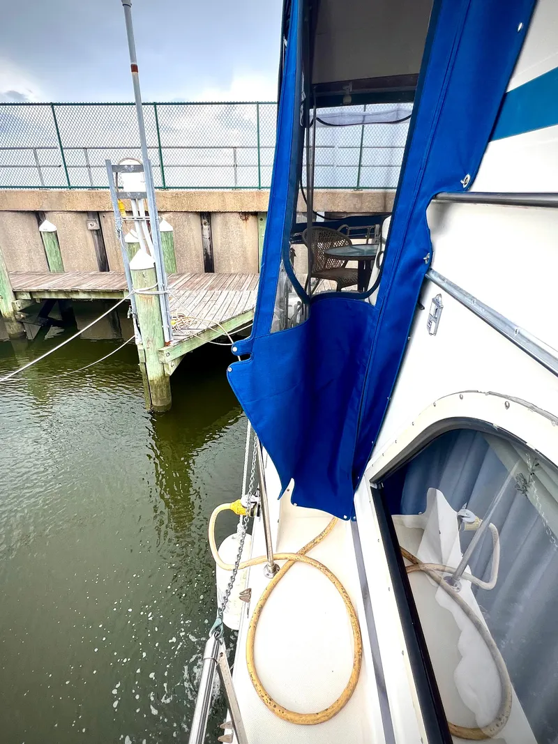Slide: The Image of 1986 Chris-Craft 480 Corinthian docked, featuring blue canopy and deck details. - 18