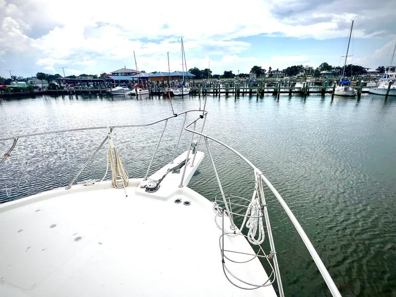 Slide: The Image of 1986 Chris-Craft 480 Corinthian yacht docked in a serene marina setting. - 19