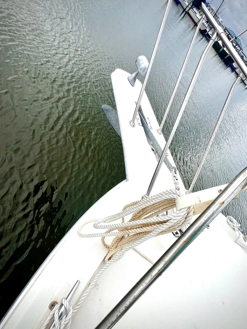 Slide: The Image of 1986 Chris-Craft 480 Corinthian yacht bow with ropes, docked in calm waters. - 20