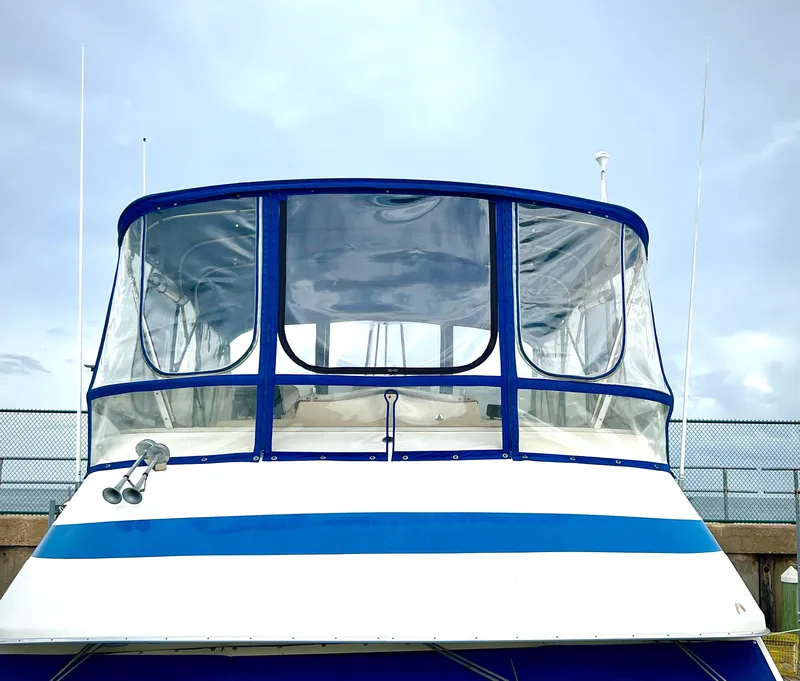 Slide: The Image of 1986 Chris-Craft 480 Corinthian boat with blue and white exterior, docked under a clear sky. - 23
