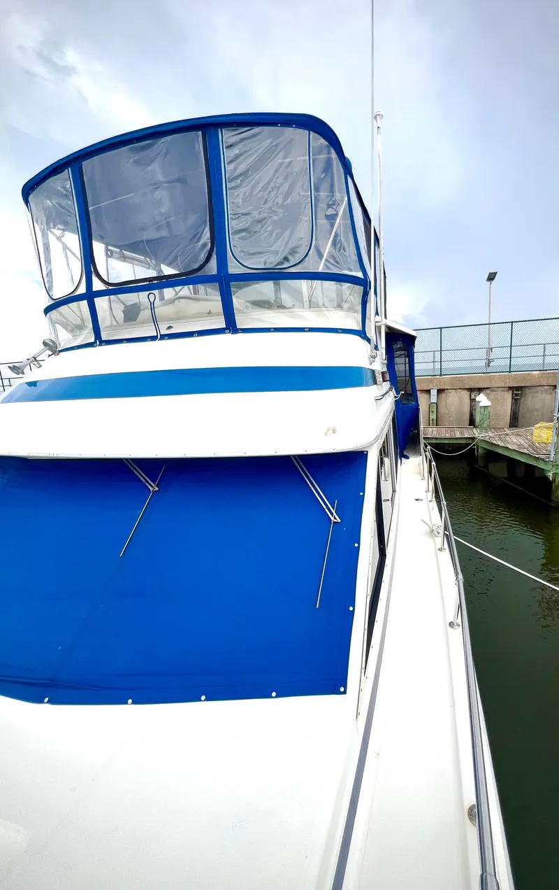 Slide: The Image of 1986 Chris-Craft 480 Corinthian yacht with blue canopy docked at marina. - 24