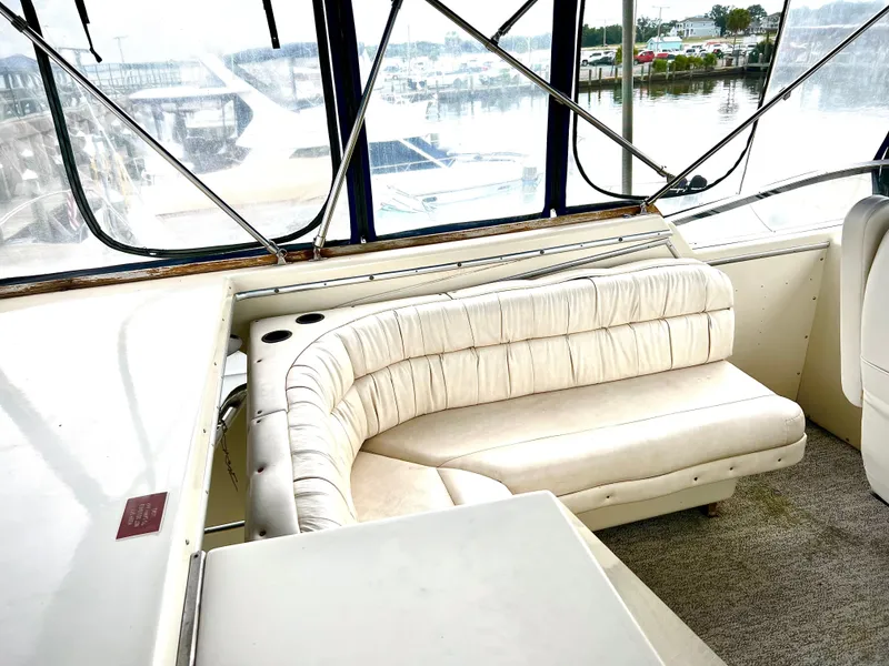 Slide: The Image of 1986 Chris-Craft 480 Corinthian yacht interior with curved seating and marina view. - 28