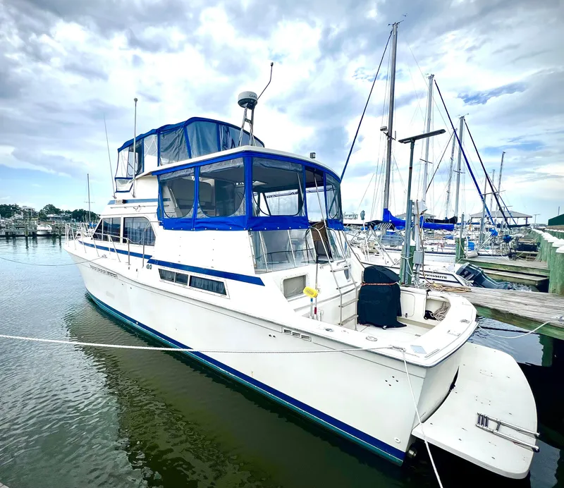 Slide: The Image of 1986 Chris-Craft 480 Corinthian yacht docked at marina under cloudy sky. - 3