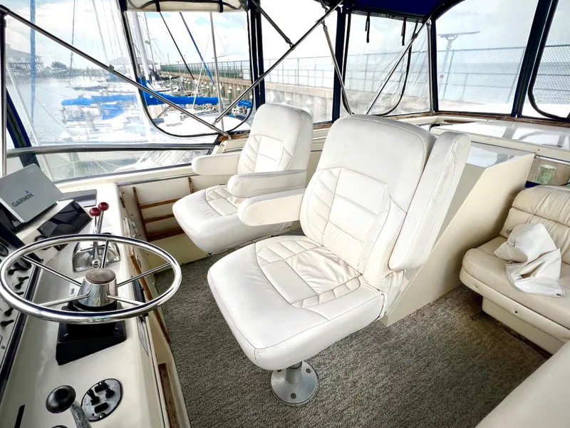 Slide: The Image of 1986 Chris-Craft 480 Corinthian yacht interior with white captain chairs and steering wheel. - 31