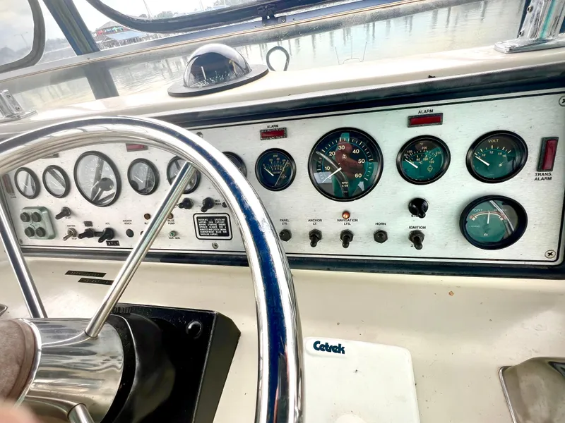 Slide: The Image of Dashboard of 1986 Chris-Craft 480 Corinthian boat with gauges and steering wheel. - 36