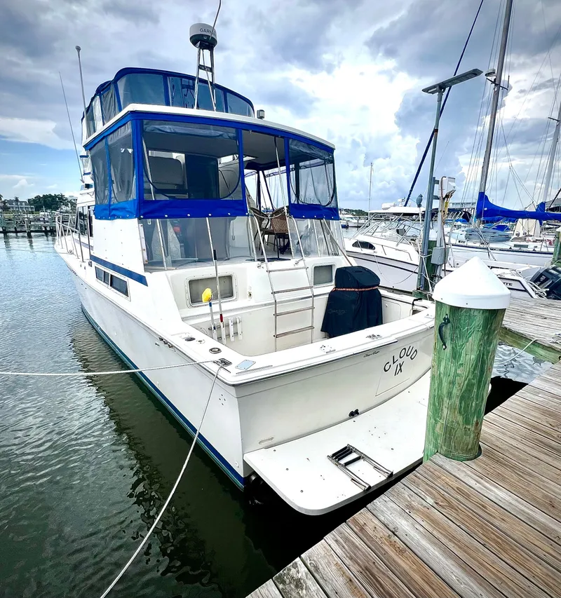 Slide: The Image of 1986 Chris-Craft 480 Corinthian yacht docked at marina under cloudy sky. - 4