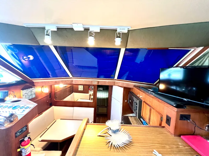 Slide: The Image of Interior of 1986 Chris-Craft 480 Corinthian yacht with modern amenities and blue-tinted windows. - 42