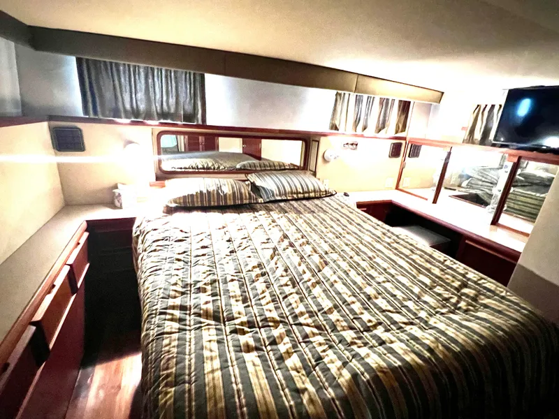 Slide: The Image of Luxurious bedroom interior of 1986 Chris-Craft 480 Corinthian yacht with striped bedding. - 47