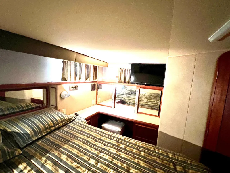 Slide: The Image of Cozy bedroom in 1986 Chris-Craft 480 Corinthian yacht with striped bedding and TV. - 48