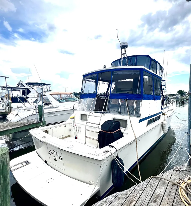 Slide: The Image of 1986 Chris-Craft 480 Corinthian yacht docked at marina under cloudy sky. - 6