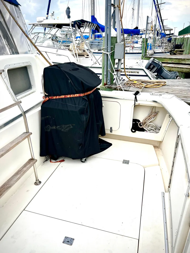Slide: The Image of 1986 Chris-Craft 480 Corinthian yacht deck with covered equipment, docked at marina. - 8