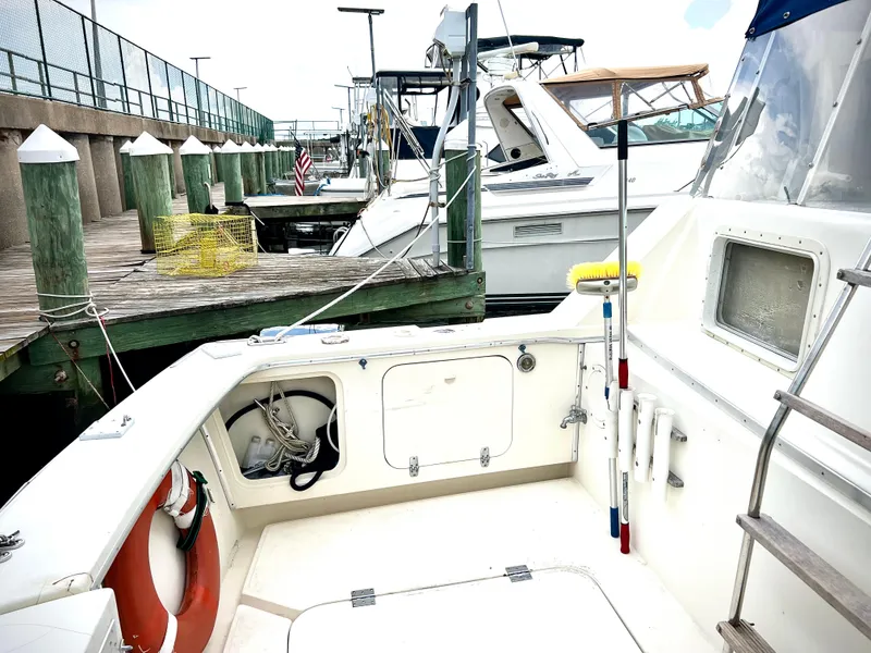 Slide: The Image of 1986 Chris-Craft 480 Corinthian docked at marina, showing deck and nearby boats. - 9