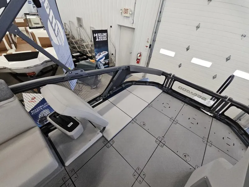 Slide: The Image of 2024 Sea-Doo Switch® Sport Compact interior, showcasing seating and deck layout in a showroom. - 8