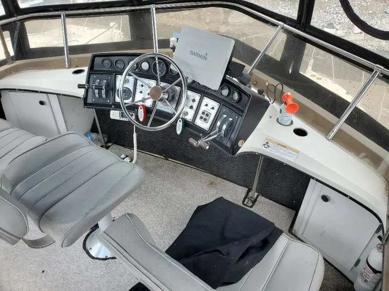 Slide: The Image of 1983 Carver 3207 AFT Cabin Motor Yacht helm with steering wheel and navigation equipment. - 12